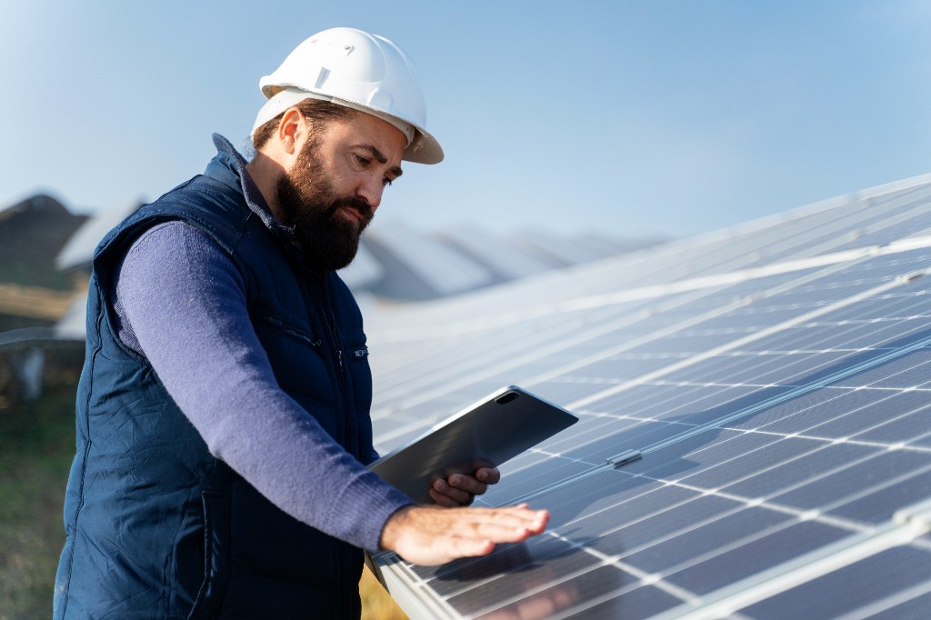 Fachmann prüft eine Photovoltaikanlage mit Tablet